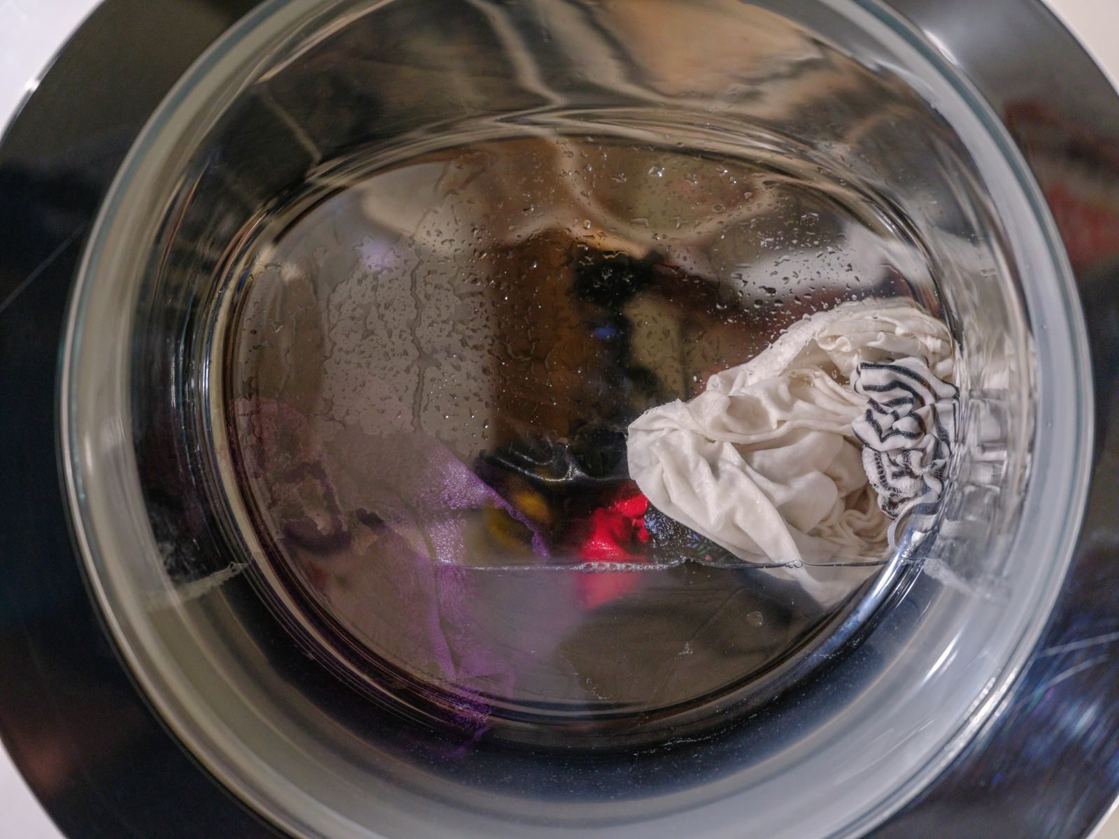Clothes tumbling behind the glass door of a front-load washer
