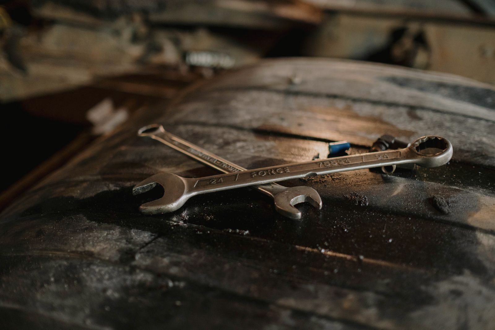 Open-end wrenches resting on a worn workbench